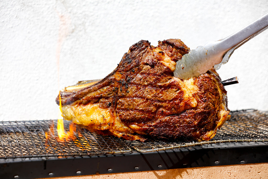 Chef de-boning and carving a portion of barbecued prime rib steak